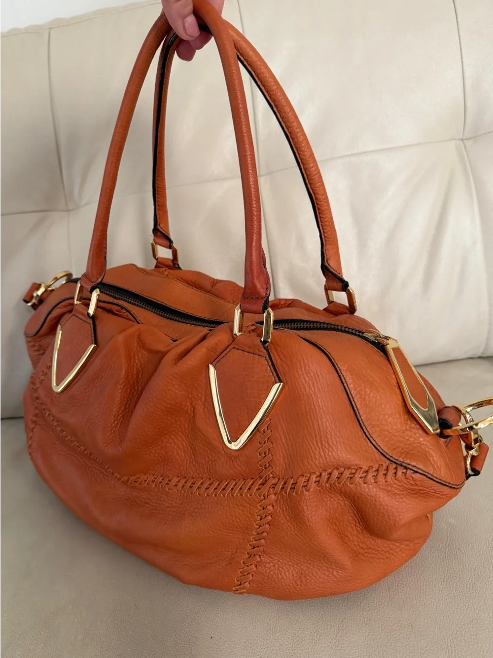 Orange leather handbag appears to be a slouchy style by orYany